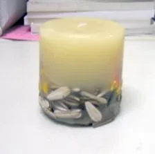 Decorative candle with sunflower seeds in the shape of a cylinder